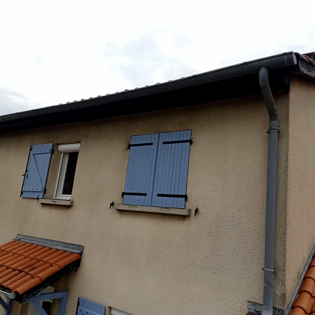 Volet bleu sur maison en rénovation à Toulouse, symbole de travaux en Occitanie.