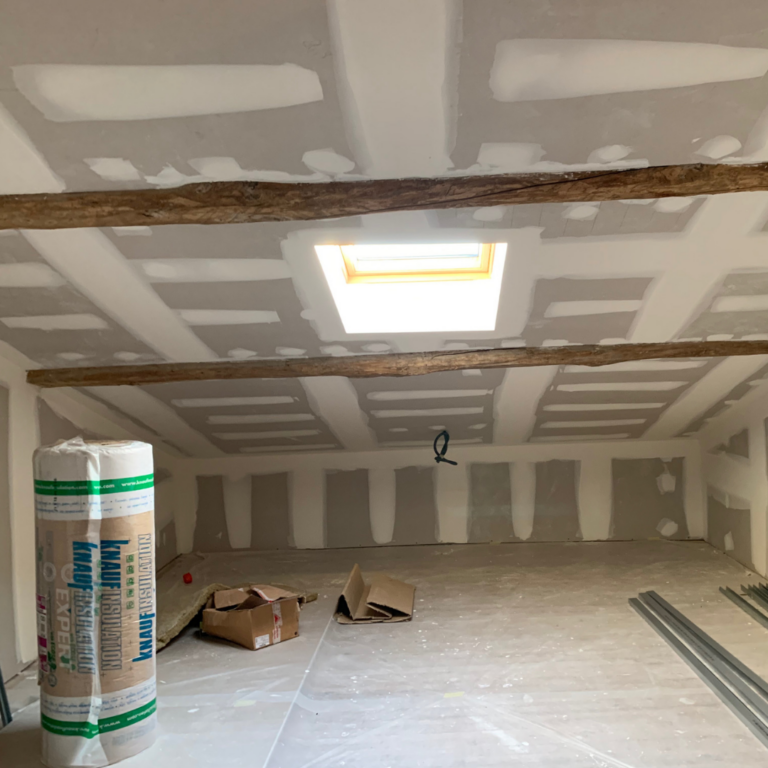 "Intérieur en cours de rénovation énergétique à Toulouse, avec poutres en bois."