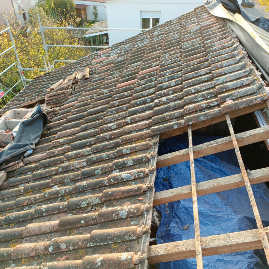 Toit en rénovation avec tuiles usées à Toulouse, travaux de rénovation énergétique.