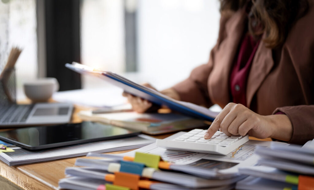 Personne utilisant une calculatrice pour AD VALIDEM audit énergétique rénovation énergétique.
