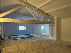 Intérieur d'une pièce rénovée avec poutres apparentes, AD VALIDEM; Rénovation énergétique.