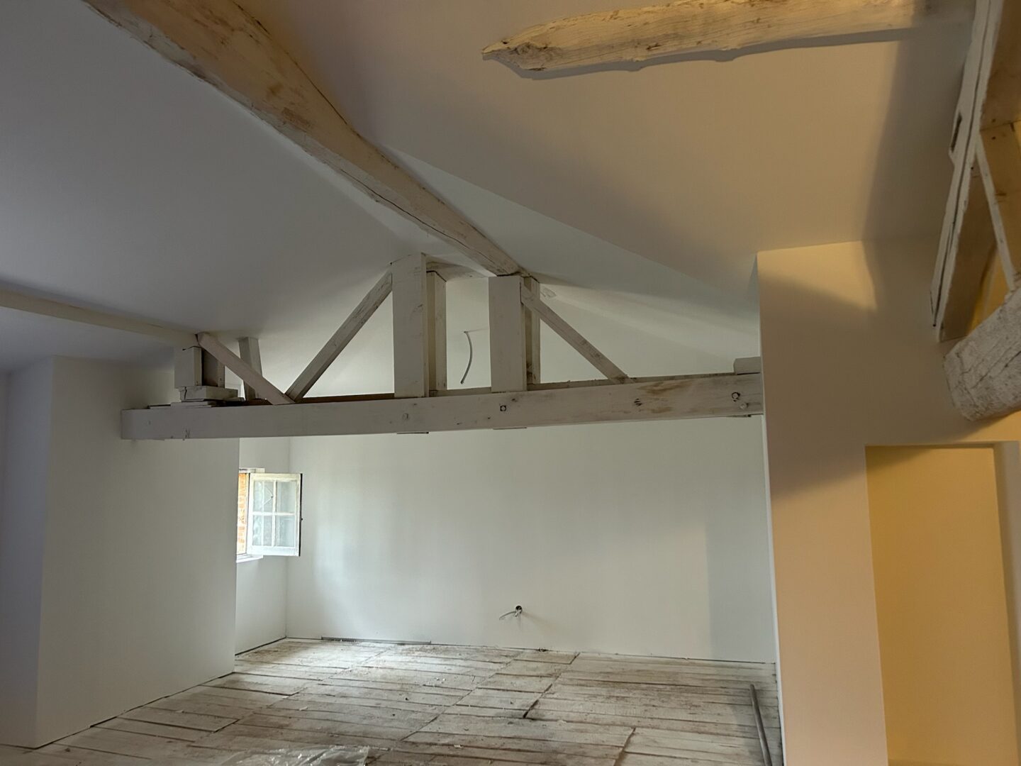 Intérieur rénové avec poutres apparentes, projet AD VALIDEM de rénovation énergétique.