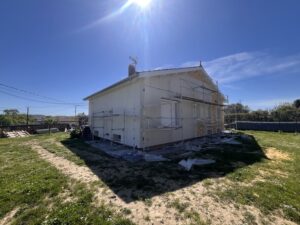 Maison en rénovation énergétique par AD VALIDEM, avec échafaudages visibles.