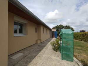 Vue latérale d'une maison rénovée avec AD VALIDEM pour la rénovation énergétique.