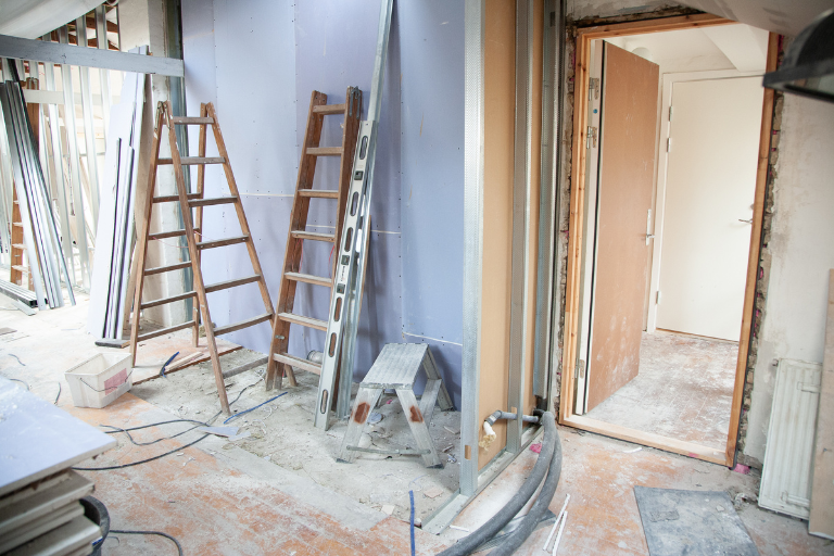 Chantier de rénovation énergétique AD VALIDEM avec échelles et matériaux.